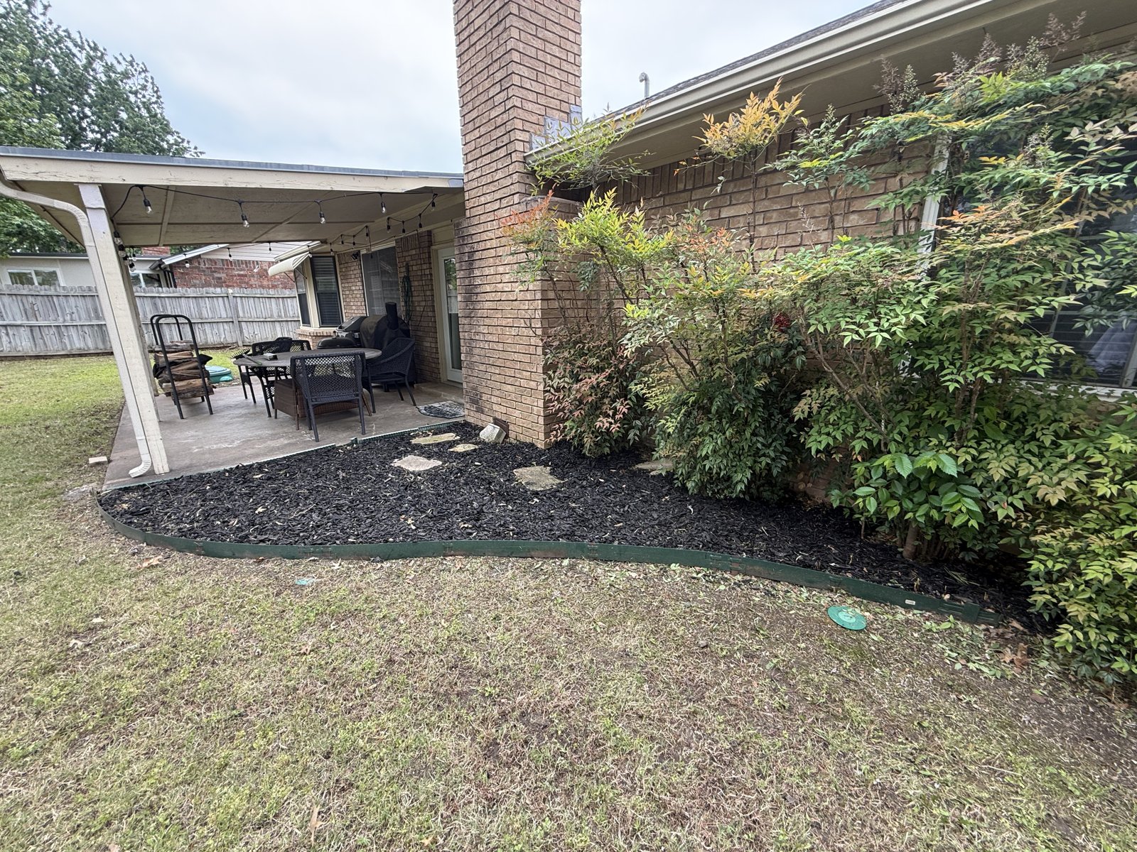EllCo fresh mulch bed and clean edging along a covered Tulsa patio